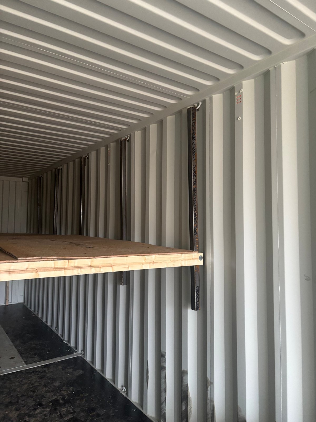 Motorcycle storage on upper level of container shelving